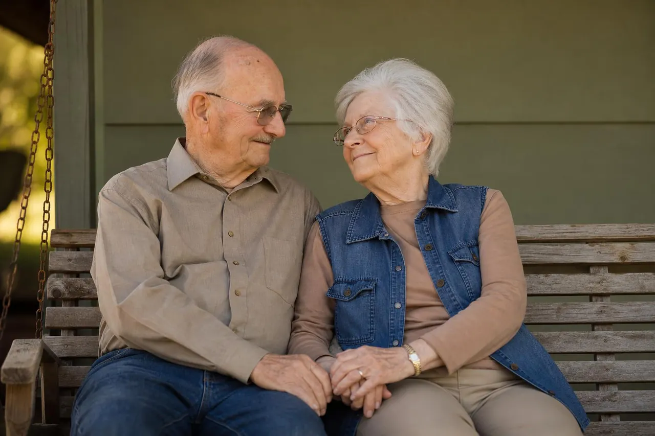 American couple in their 70s sitting together reviewing a golden anniversary gift, warm afternoon lighting, genuine emotion