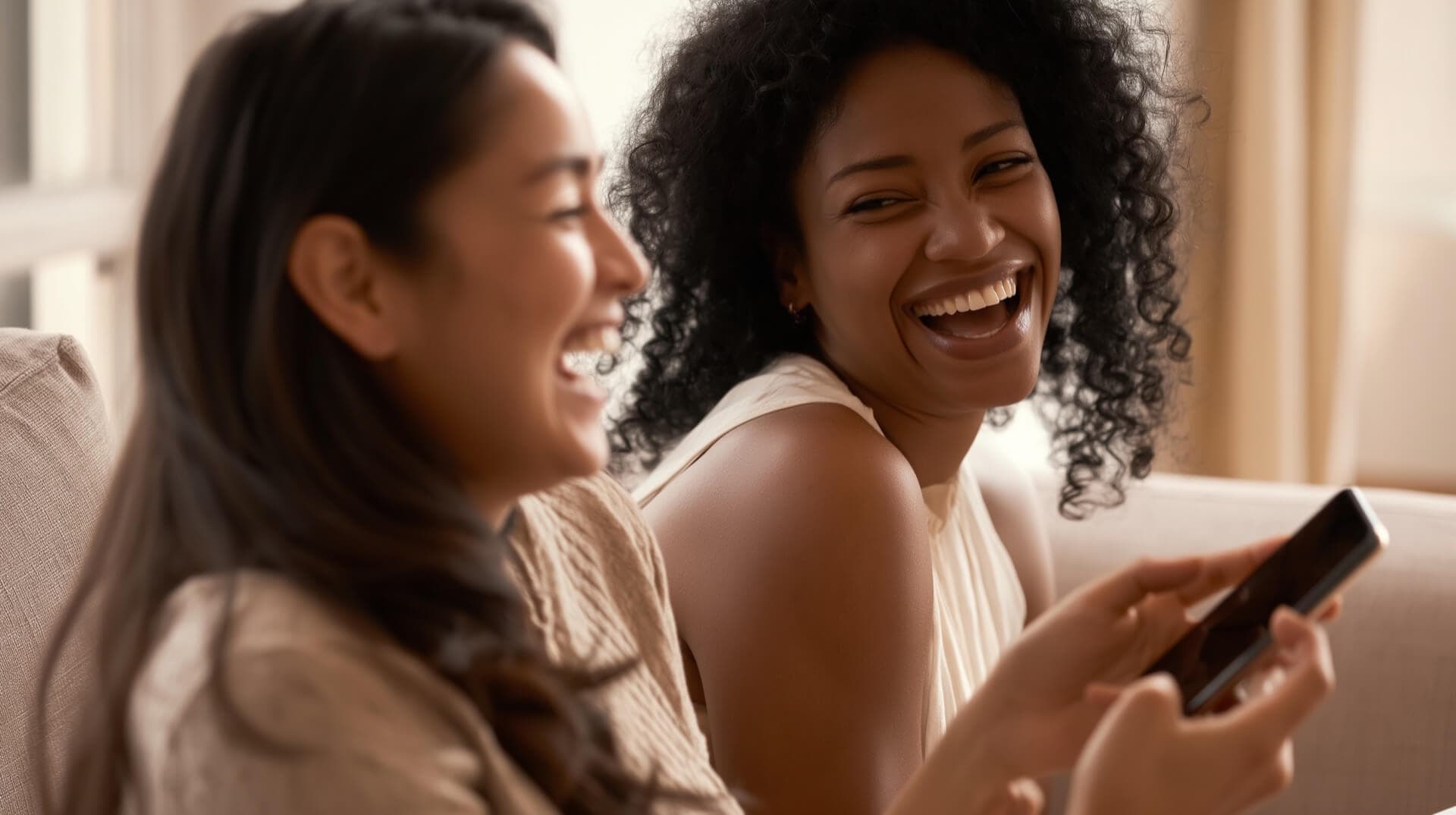 Two friends laughing while listening to a personalized birthday song on a phone — birthday song ideas for her