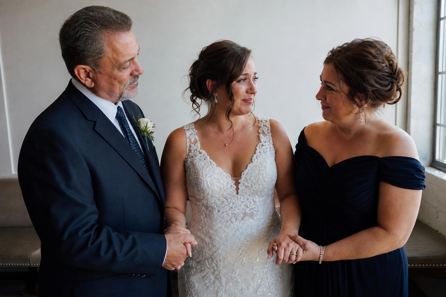 Noiva emocionada com os pais antes da cerimônia de casamento