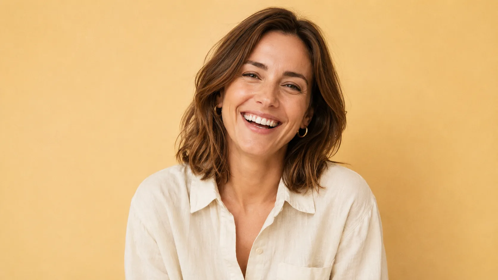 Portrait of Sarah at 35 — American woman with warm-brown hair and gentle laugh, cream linen shirt